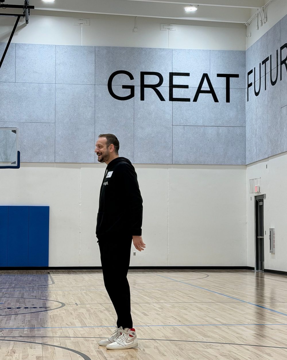 Eric Hall on a basketball court under a Great Futures sign
