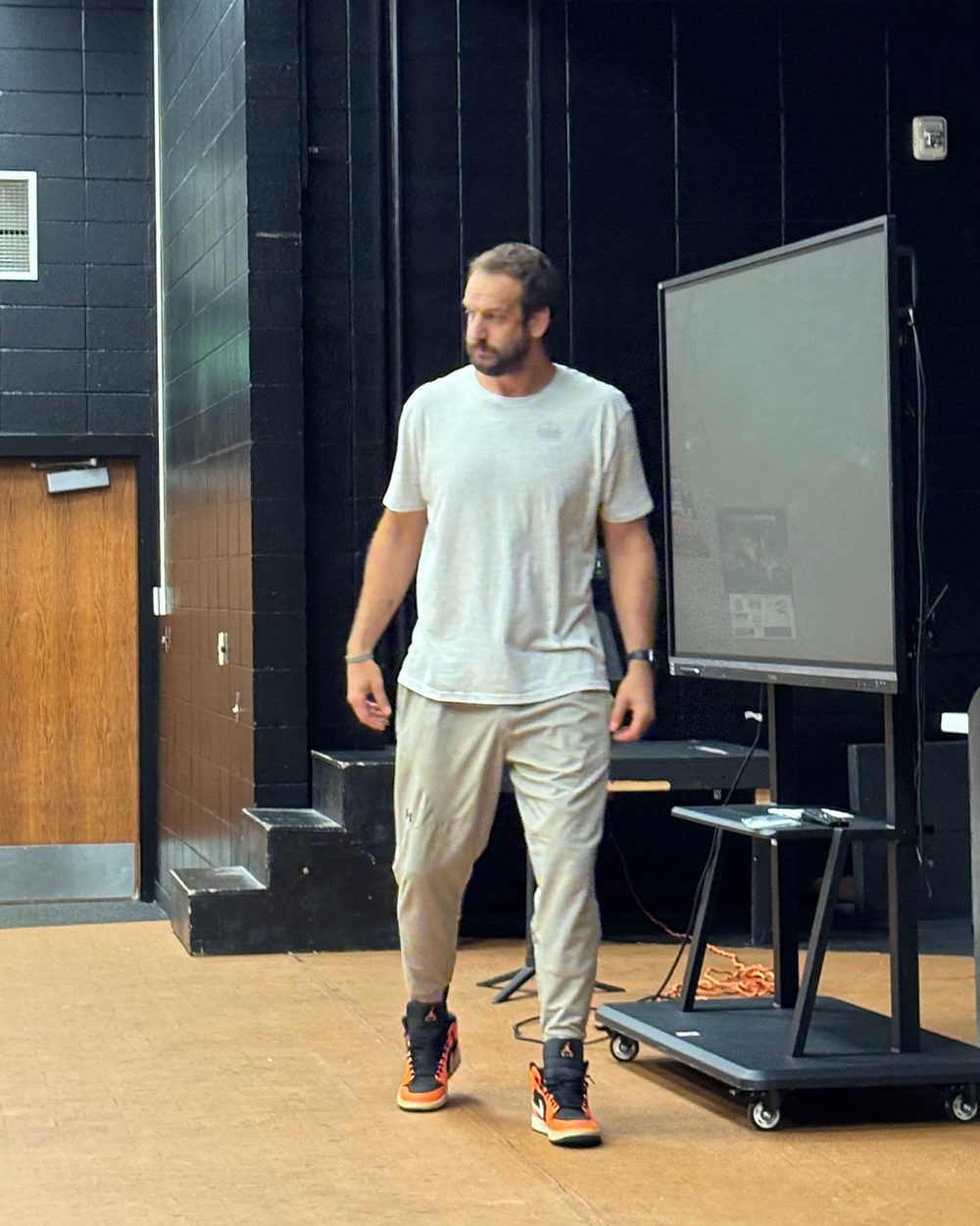 Eric Hall speaking, orange and black sneakers in frame