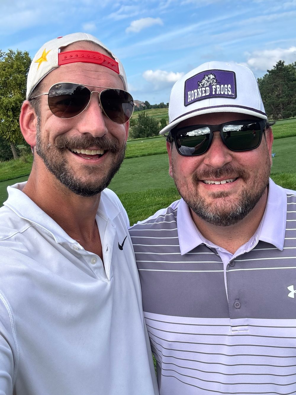 Eric Hall and a friend smiling on a golf course